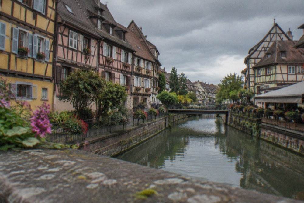 Half timbered houses along a canal in Colmar old town on a bright afternoon