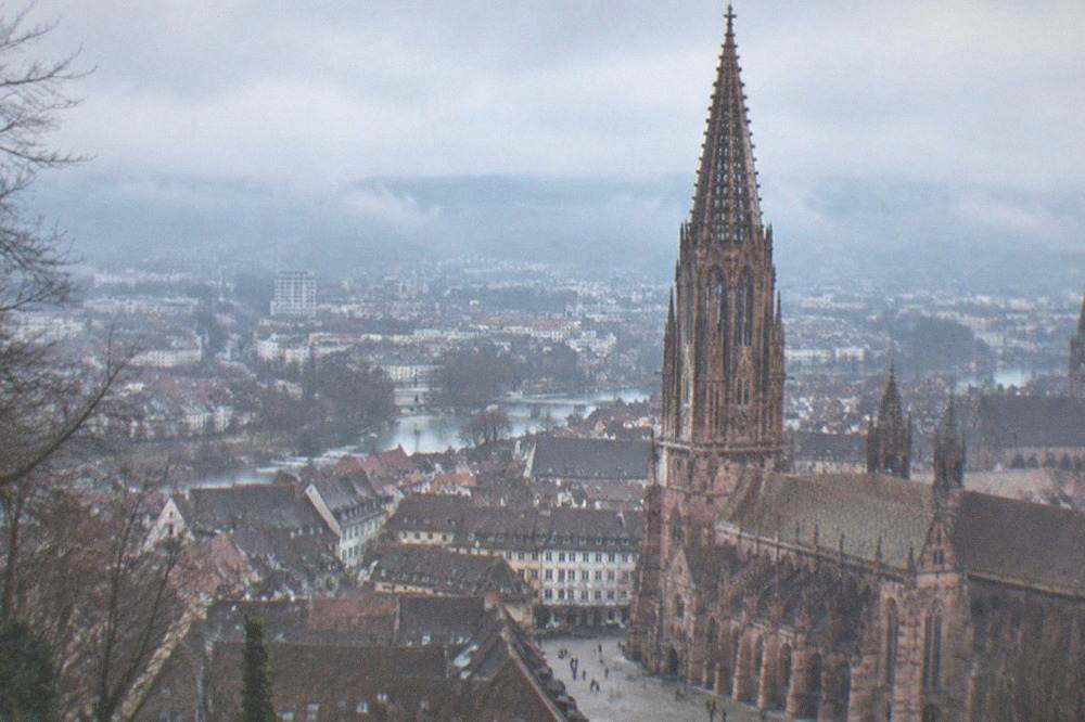 Fog-covered Freiburg rooftops seen from the Schlossberg on a cold clear afternoon