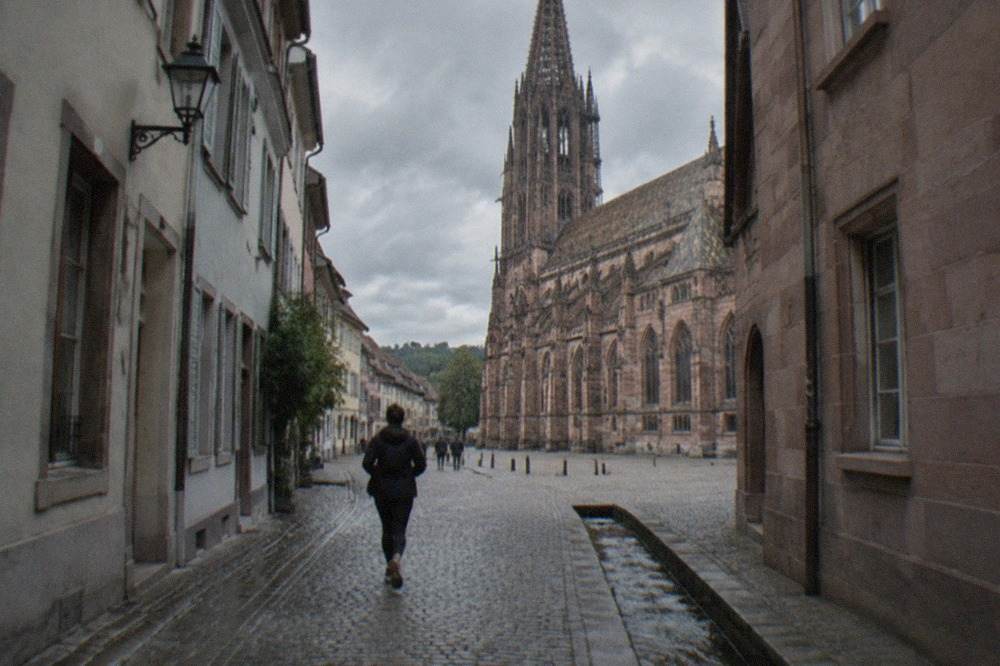 Narrow old town lane in Freiburg with a small water channel running along the cobblestones