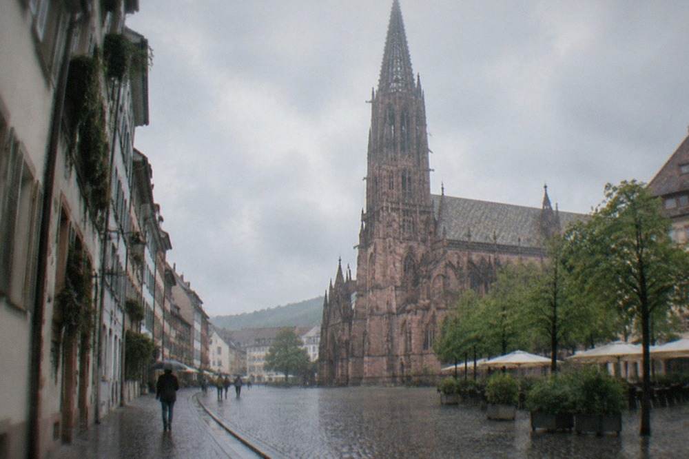 Rain falling on the wet cobblestones of a narrow Freiburg lane with water running along the gutter channel
