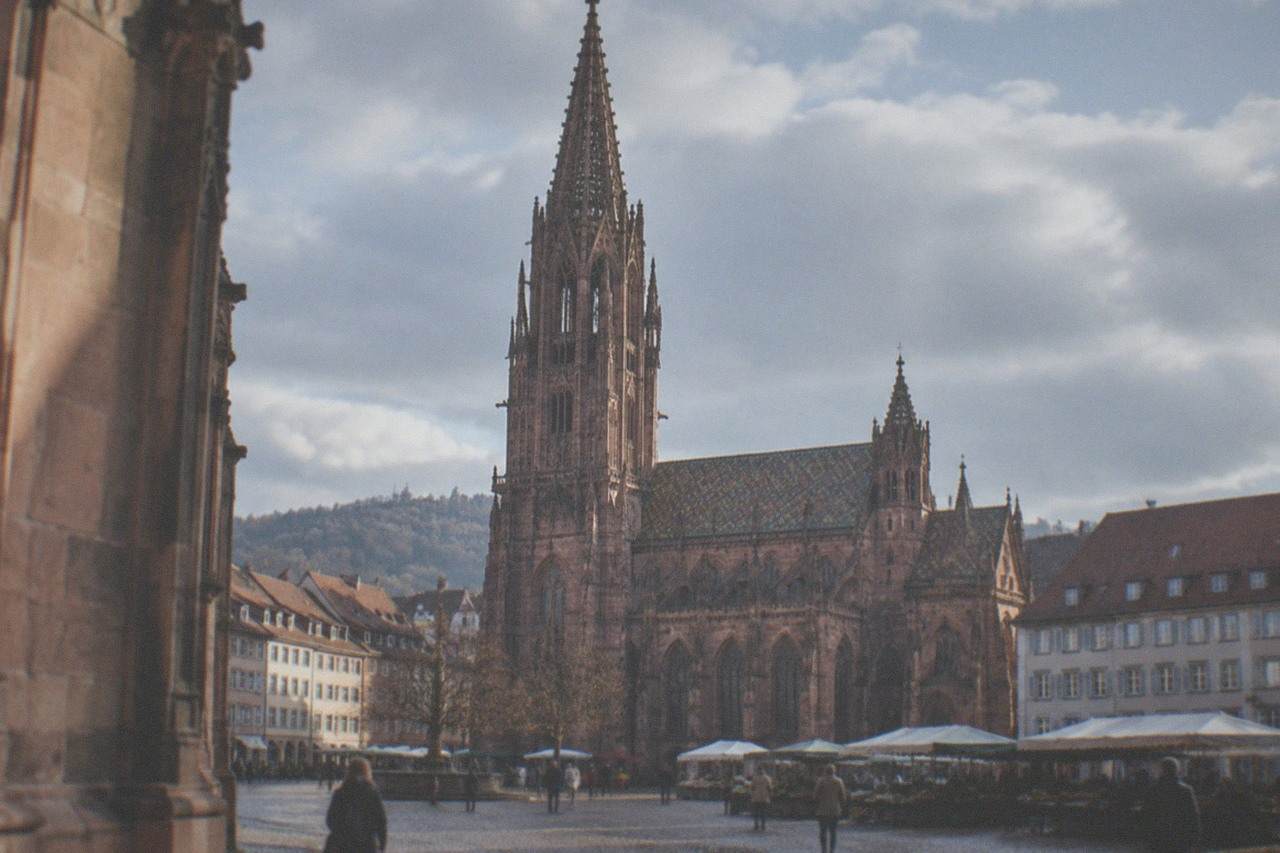 Freiburg Münster rising above red rooftops and the market square on a clear morning