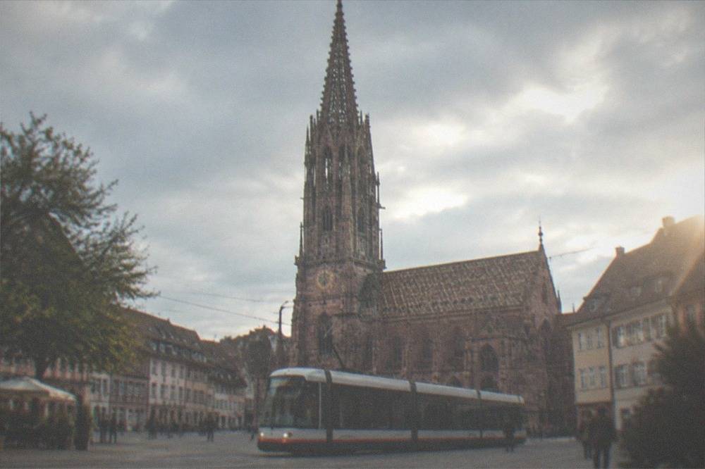 Freiburg tram passing through the old town with the Minster tower behind